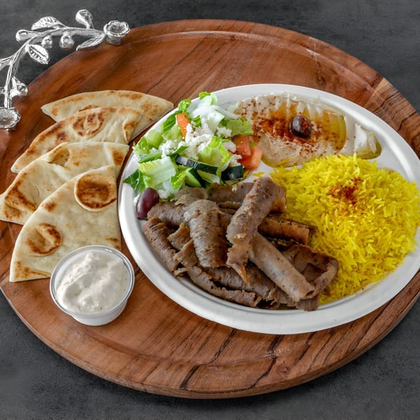 Niro's House Mediterranean Kitchen gyro plate with meat, yellow rice, hummus, salad, pita, and tzatziki.