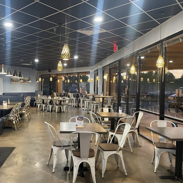 The spacious dining area of Niro's House Mediterranean Kitchen, featuring modern tables and chairs.