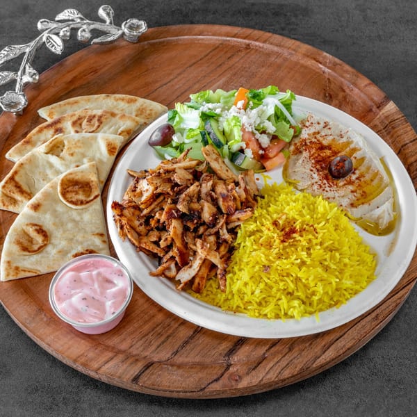 Niro's House Mediterranean Kitchen's chicken shawarma plate with rice, salad, hummus, pita, and pink sauce.