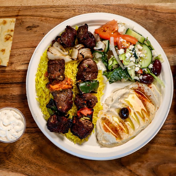 Niro's House Mediterranean Kitchen's beef and vegetable skewers with yellow rice, salad, and hummus.