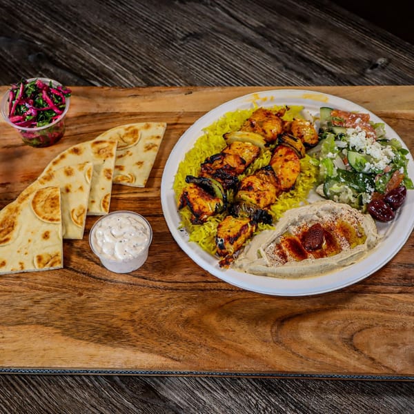 Niro's House Mediterranean Kitchen's chicken shish tawook plate with rice, salad, hummus, pita, and sauces.